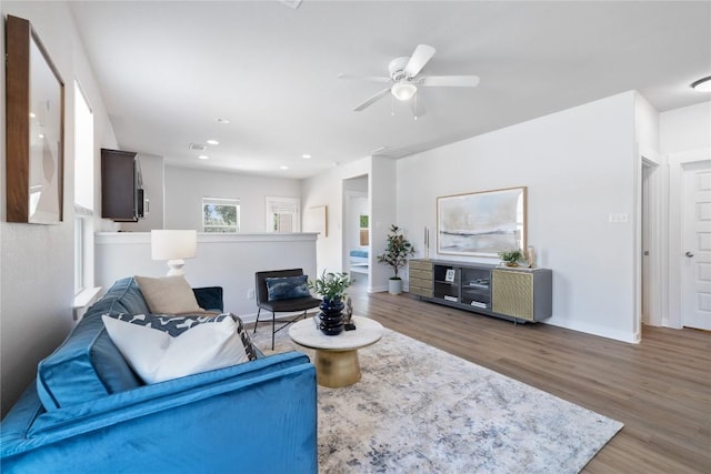 129 Syrah Ct, Leander, TX 78641 - living room with wood finished floors, a ceiling fan, a glass covered fireplace, baseboards, and recessed lighting