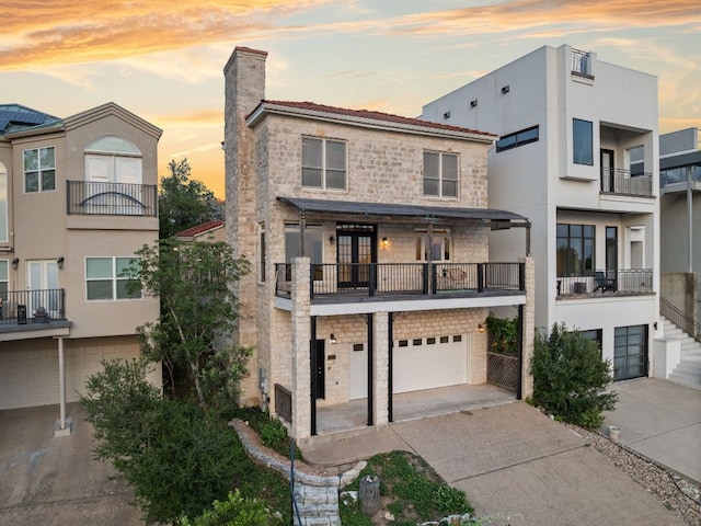 5913 N W Pl, Austin, TX 78731 - view of front facade with a garage, concrete driveway, a chimney, stone siding, and stucco siding