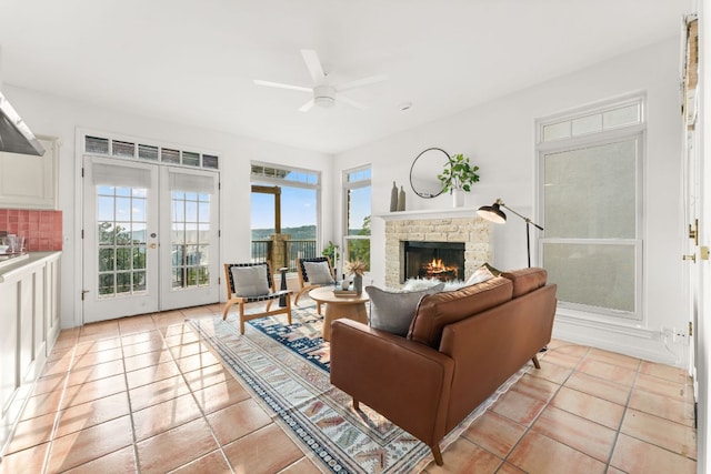 5913 N W Pl, Austin, TX 78731 - living room with a ceiling fan, french doors, a lit fireplace, and light tile patterned flooring