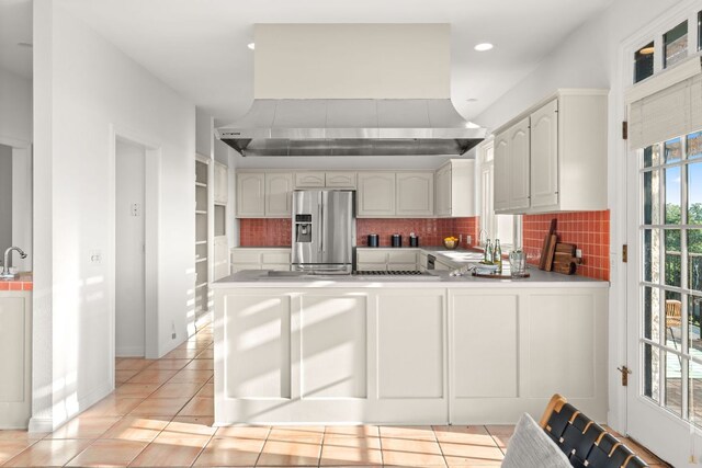 5913 N W Pl, Austin, TX 78731 - kitchen with stainless steel fridge with ice dispenser, wall chimney exhaust hood, decorative backsplash, a peninsula, and recessed lighting