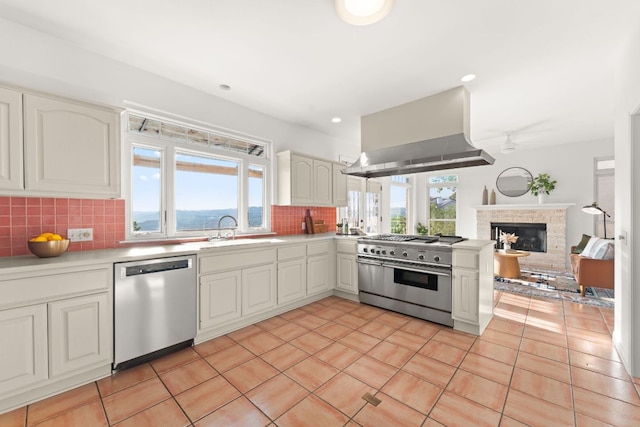 5913 N W Pl, Austin, TX 78731 - kitchen featuring appliances with stainless steel finishes, wall chimney exhaust hood, plenty of natural light, tasteful backsplash, and recessed lighting