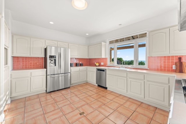 5913 N W Pl, Austin, TX 78731 - kitchen featuring appliances with stainless steel finishes, light countertops, decorative backsplash, a sink, and recessed lighting