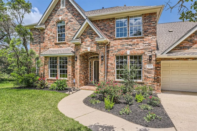 10672 Bramblecrest Dr, Austin, TX 78726 - traditional home featuring roof with shingles, a front yard, brick siding, driveway, and a garage