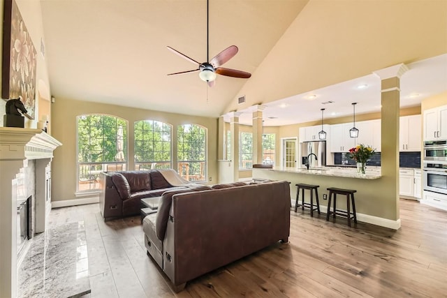10672 Bramblecrest Dr, Austin, TX 78726 - living room with ceiling fan, hardwood / wood-style flooring, plenty of natural light, ornate columns, and high vaulted ceiling