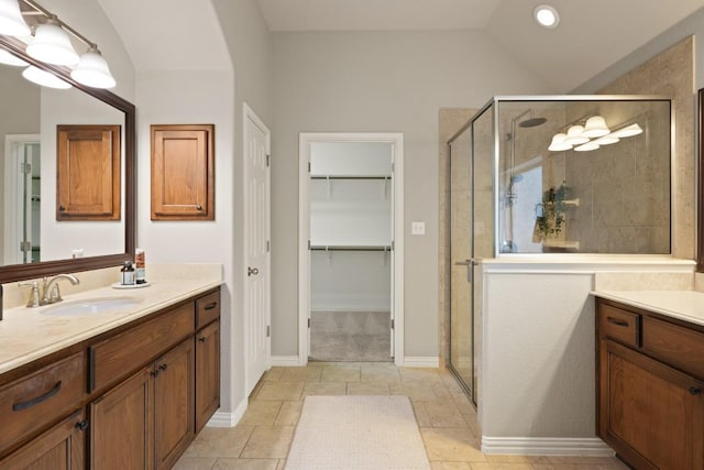 495 Catalina Ln, Austin, TX 78737 - bathroom featuring vanity, a shower stall, vaulted ceiling, a walk in closet, and tile patterned flooring