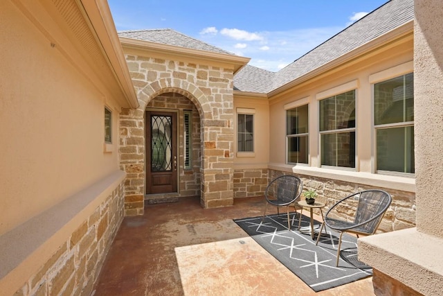 495 Catalina Ln, Austin, TX 78737 - property entrance featuring stone siding, roof with shingles, a patio, and stucco siding