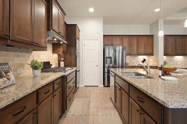 495 Catalina Ln, Austin, TX 78737 - kitchen with under cabinet range hood, a sink, stainless steel appliances, a kitchen island with sink, and light stone countertops