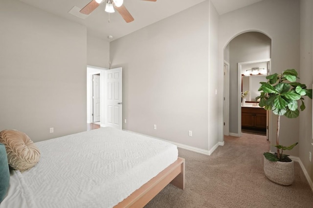 495 Catalina Ln, Austin, TX 78737 - bedroom with arched walkways, light carpet, baseboards, and connected bathroom