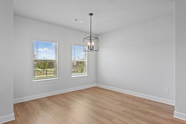 9312 Gladsome Path, Manor, TX 78653 - empty room with light wood-type flooring, a chandelier, and baseboards