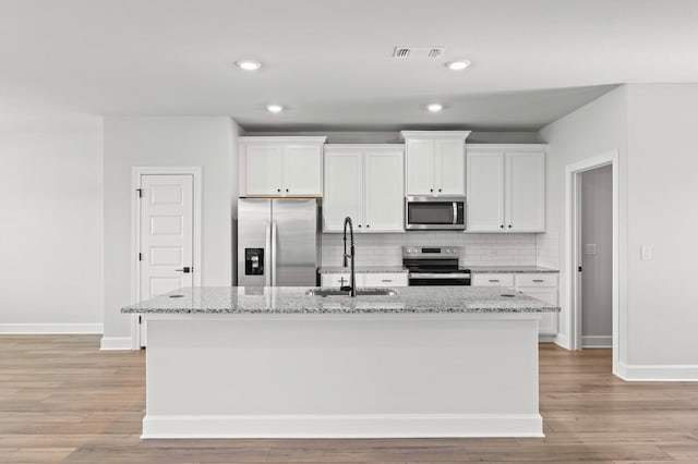 9312 Gladsome Path, Manor, TX 78653 - kitchen featuring stainless steel appliances, a sink, baseboards, white cabinets, and recessed lighting