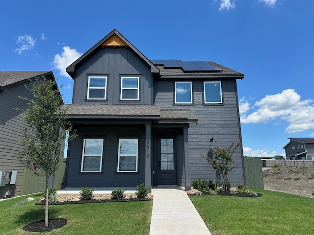 9513 Balmy Ln, Manor, TX 78653 - view of front of home featuring roof mounted solar panels, covered porch, a shingled roof, and board and batten siding