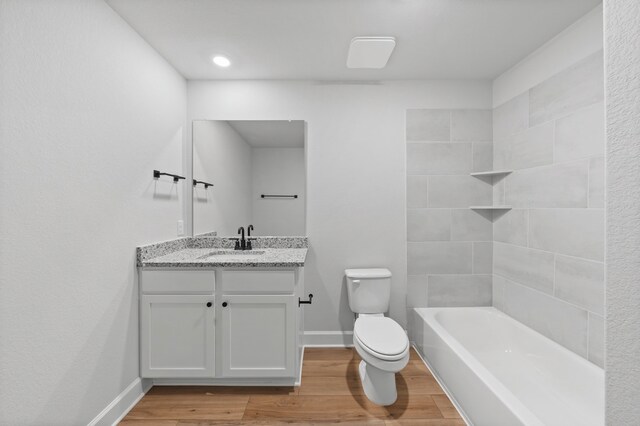 9513 Balmy Ln, Manor, TX 78653 - bathroom with toilet, vanity, wood finished floors, baseboards, and shower / bath combination