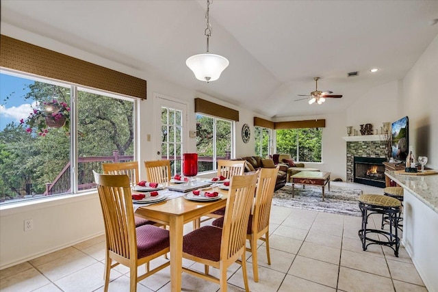 5801 Taylor Draper Cv, Austin, TX 78759 - dining room featuring light tile patterned floors, a ceiling fan, a stone fireplace, and vaulted ceiling