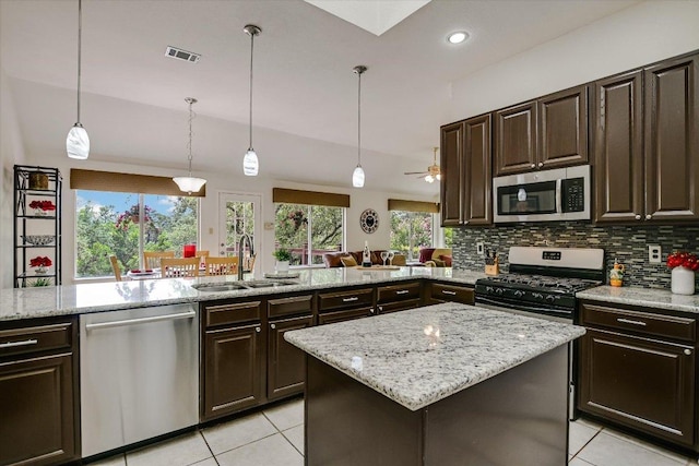 5801 Taylor Draper Cv, Austin, TX 78759 - kitchen featuring appliances with stainless steel finishes, light tile patterned flooring, dark brown cabinetry, and recessed lighting