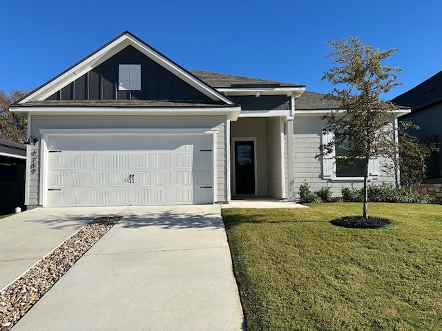 9709 Gladsome Path, Manor, TX 78653 - view of front of property with concrete driveway, a front lawn, a garage, and board and batten siding