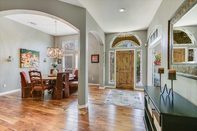 12505 Stapp Ct, Austin, TX 78732 - entryway featuring arched walkways, light wood-type flooring, a chandelier, and baseboards