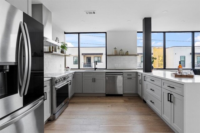 1800 E 4th St Unit 396, Austin, TX 78702 - kitchen with stainless steel appliances, open shelves, light wood-style floors, healthy amount of natural light, and recessed lighting