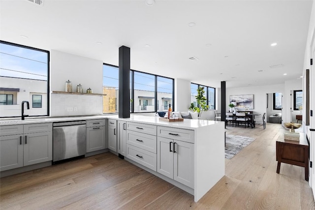 1800 E 4th St Unit 396, Austin, TX 78702 - kitchen featuring stainless steel dishwasher, light wood-type flooring, a peninsula, a sink, and light countertops