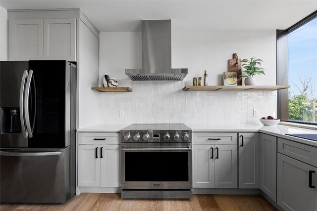 1800 E 4th St Unit 396, Austin, TX 78702 - kitchen featuring stainless steel appliances, wall chimney range hood, open shelves, and tasteful backsplash
