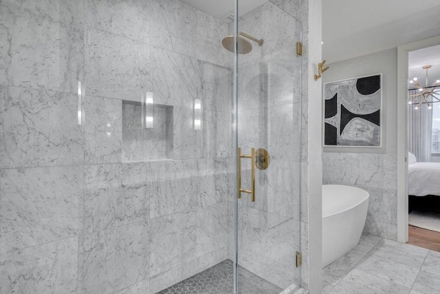 222 W Ave Unit 1614, Austin, TX 78701 - ensuite bathroom featuring a soaking tub, a marble finish shower, and tile walls