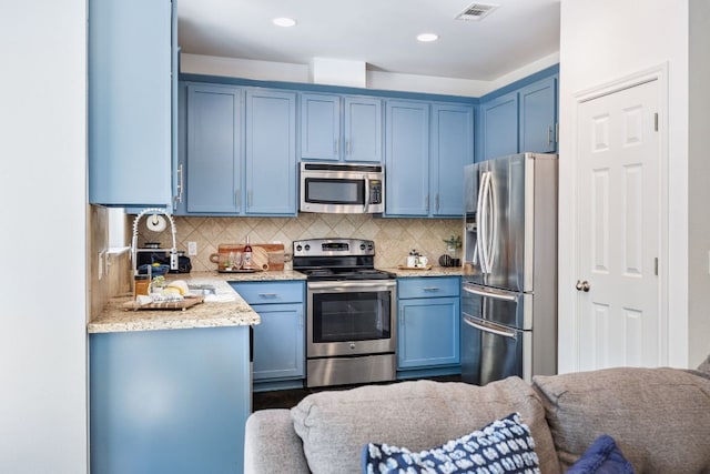 3407 Banton Rd Unit A, Austin, TX 78722 - kitchen with appliances with stainless steel finishes, blue cabinets, light stone countertops, tasteful backsplash, and open floor plan