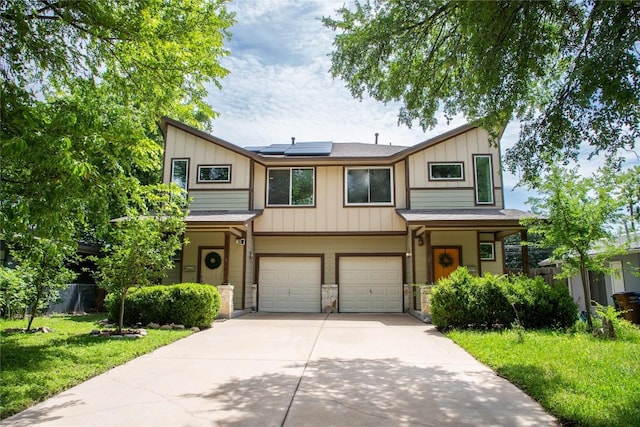 3407 Banton Rd Unit A, Austin, TX 78722 - view of property featuring board and batten siding, a garage, roof mounted solar panels, driveway, and stone siding