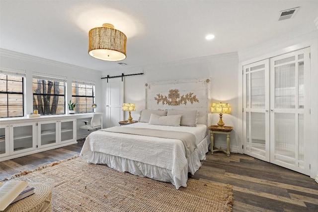 119 Vicinity Trl, Spicewood, TX 78669 - bedroom with a barn door, crown molding, wood finished floors, and recessed lighting