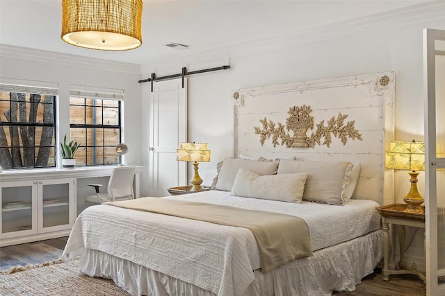 119 Vicinity Trl, Spicewood, TX 78669 - bedroom with ornamental molding, a barn door, and wood finished floors