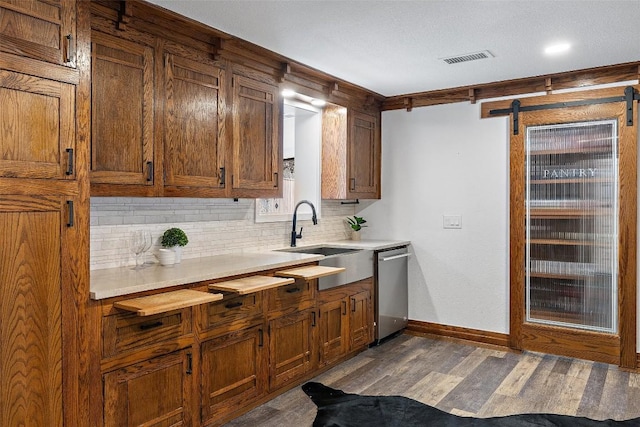 119 Vicinity Trl, Spicewood, TX 78669 - kitchen with a sink, stainless steel dishwasher, decorative backsplash, dark wood finished floors, and light countertops