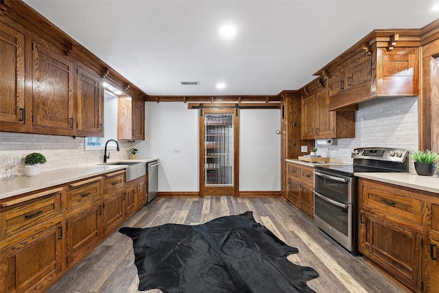 119 Vicinity Trl, Spicewood, TX 78669 - kitchen with appliances with stainless steel finishes, a sink, dark wood-style floors, decorative backsplash, and recessed lighting