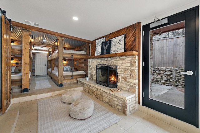 119 Vicinity Trl, Spicewood, TX 78669 - tiled living area featuring wood walls and a fireplace