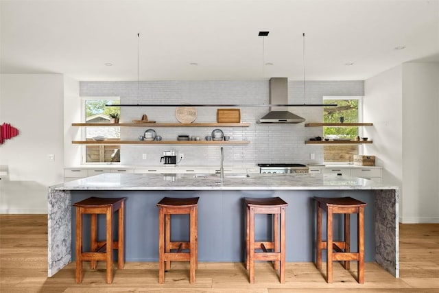 4005 Knollwood Dr, Austin, TX 78731 - bar with wall chimney exhaust hood, backsplash, range, and light wood-type flooring