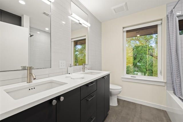 4005 Knollwood Dr, Austin, TX 78731 - full bathroom featuring double vanity, healthy amount of natural light, wood finished floors, shower / bath combination with curtain, and recessed lighting