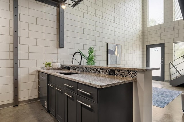 4801 S Congress Ave Unit A1, Austin, TX 78745 - kitchen with finished concrete flooring, tile walls, dishwasher, stone countertops, and healthy amount of natural light