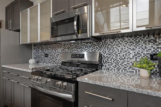 4801 S Congress Ave Unit A1, Austin, TX 78745 - kitchen featuring stainless steel appliances, backsplash, and light stone counters