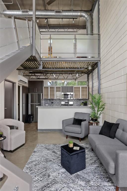 4801 S Congress Ave Unit A1, Austin, TX 78745 - living area with finished concrete flooring and a wall mounted air conditioner