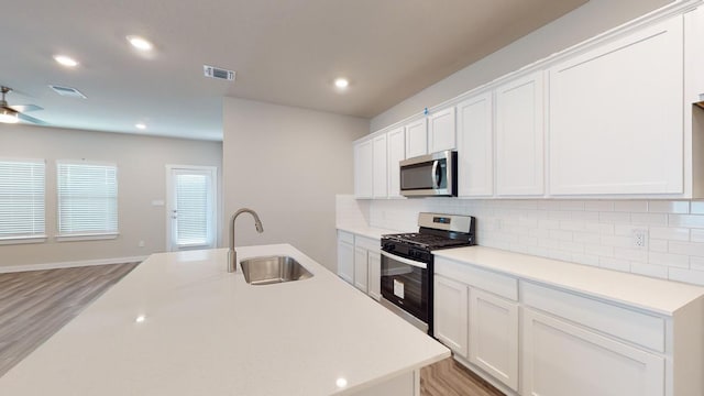 4019 Illian Cv, Killeen, TX 76542 - kitchen with appliances with stainless steel finishes, a sink, decorative backsplash, white cabinets, and recessed lighting
