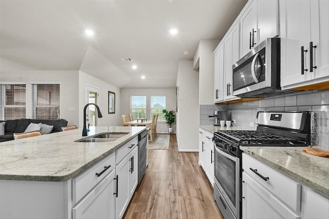 801 Russet Rock Dr Unit 6, Manchaca, TX 78748 - kitchen with appliances with stainless steel finishes, a sink, light wood-style flooring, recessed lighting, and white cabinets