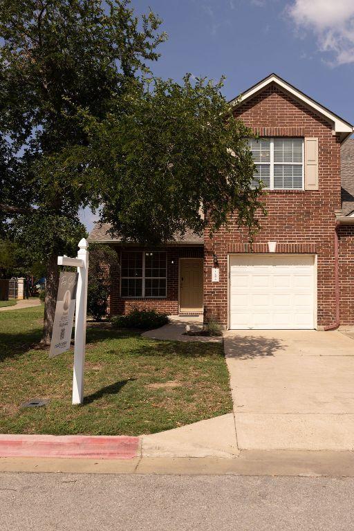 12 Verde Ranch Loop, Leander, TX 78641 - view of front of house with driveway, brick siding, a front yard, and a garage
