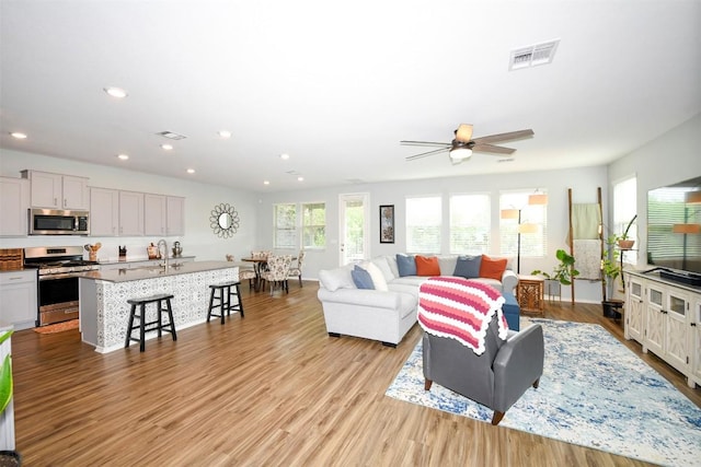 10401 Bramble Berry Dr, Austin, TX 78748 - living room featuring light wood-type flooring, a ceiling fan, and recessed lighting