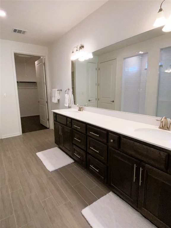 19024 Fernando Trl, Austin, TX 78738 - full bath featuring double vanity, wood finished floors, and a shower with shower door