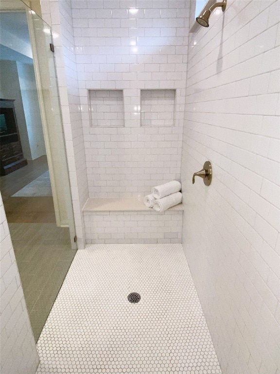 19024 Fernando Trl, Austin, TX 78738 - full bath featuring tile patterned floors, a tile shower, and a fireplace