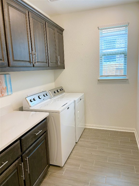 19024 Fernando Trl, Austin, TX 78738 - laundry area with washer and clothes dryer, cabinet space, baseboards, and light wood-type flooring