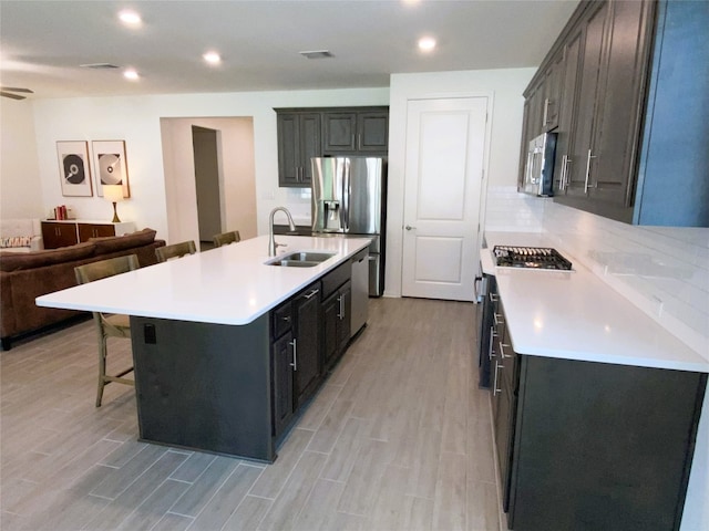 19024 Fernando Trl, Austin, TX 78738 - kitchen with a sink, a breakfast bar, stainless steel appliances, light wood-style flooring, and open floor plan