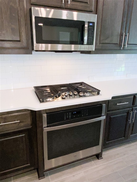 19024 Fernando Trl, Austin, TX 78738 - kitchen with appliances with stainless steel finishes, light countertops, tasteful backsplash, and dark brown cabinetry