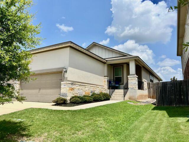 232 Serpens St, Georgetown, TX 78628 - view of front of home featuring stone siding, a garage, concrete driveway, and board and batten siding
