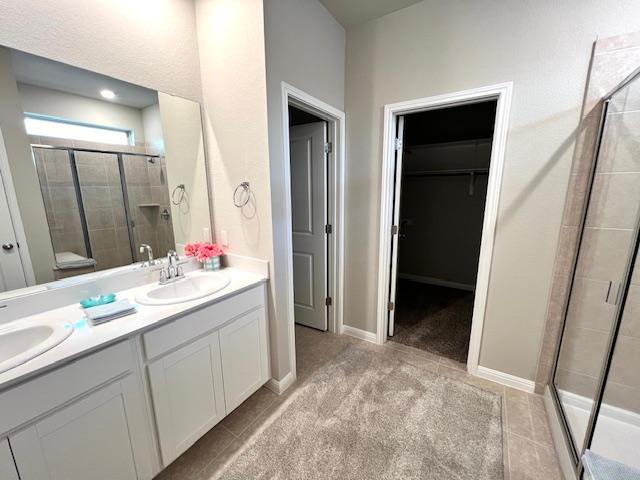 232 Serpens St, Georgetown, TX 78628 - bathroom with a shower stall, double vanity, and a walk in closet
