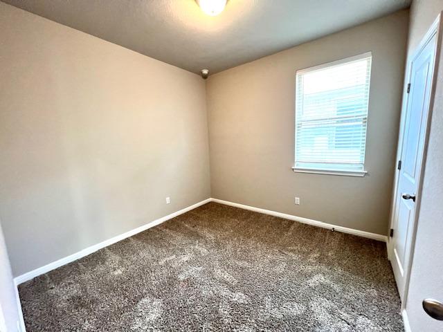 232 Serpens St, Georgetown, TX 78628 - carpeted empty room with baseboards