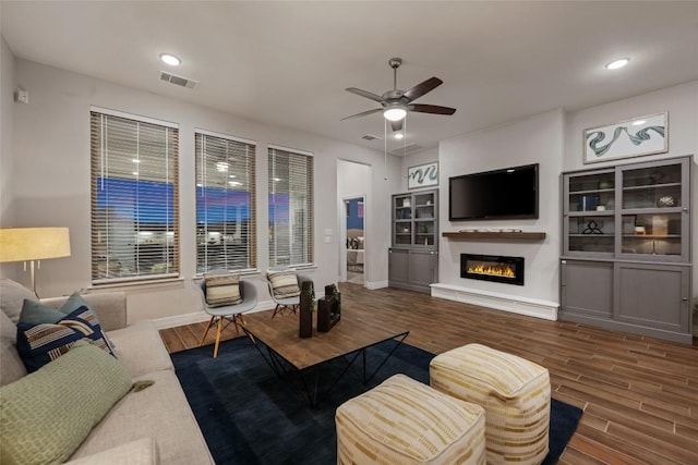 620 Saturnia Dr, Georgetown, TX 78628 - living area with wood finished floors, a ceiling fan, a glass covered fireplace, and recessed lighting