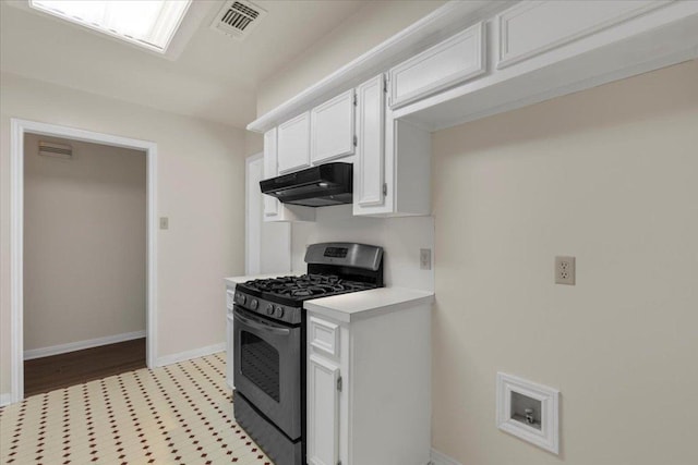910 Garwood St, Smithville, TX 78957 - kitchen featuring stainless steel range with gas cooktop, under cabinet range hood, light countertops, and white cabinetry